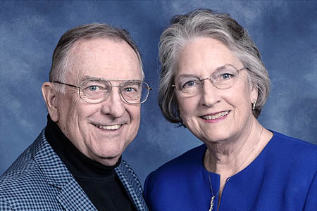 A man and woman with glasses, smiling