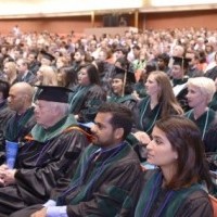 Graduates participate in hooding ceremony