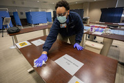 Clinical Pharmacy Manager Joshua Blackwell sanitizes a table as setup began.