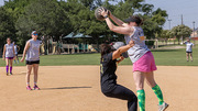 Cathy Tran (left), a Clinic Staff Assistant, tries to block Morgan Barnhart, Athletic Trainer, during the kickball match.