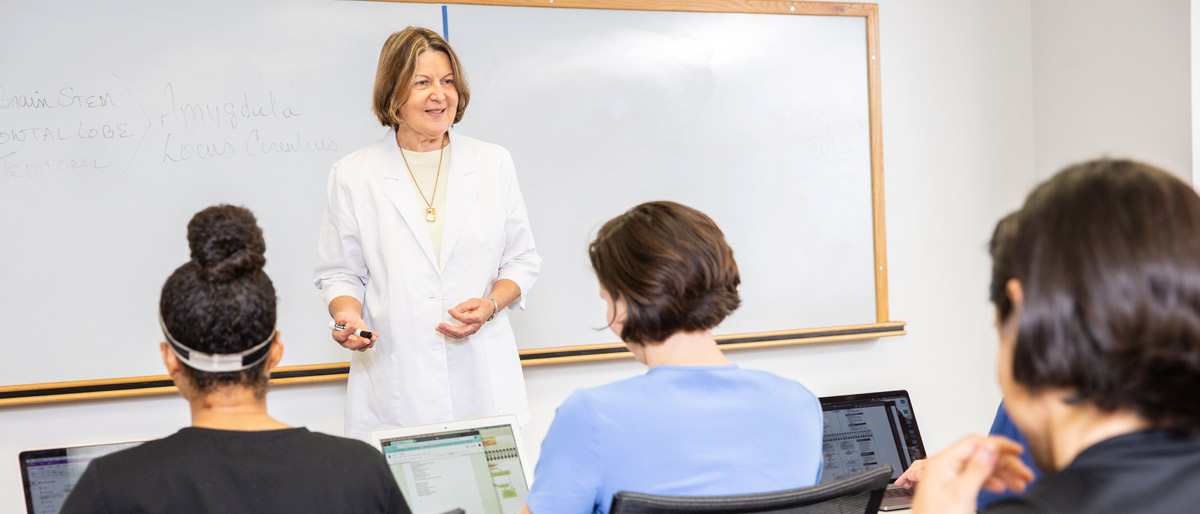 Woman dressed in white teaching a class