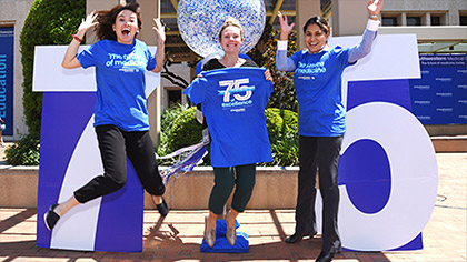 Employees jumping to celebrate the school's 75th anniversary