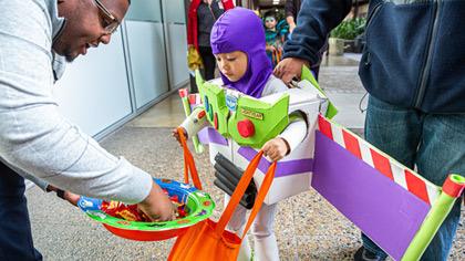 Child dressed as Buzz Lightyear picking candy