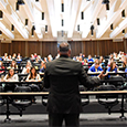 a man giving a lecture in a brightly liit lecture hall