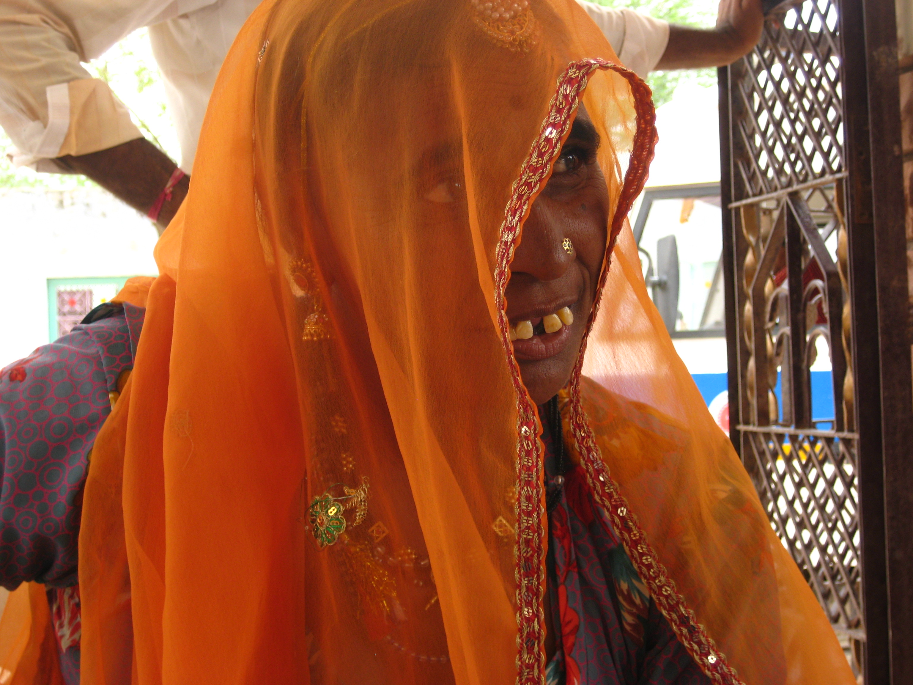 Indian woman with orange scarf over her head