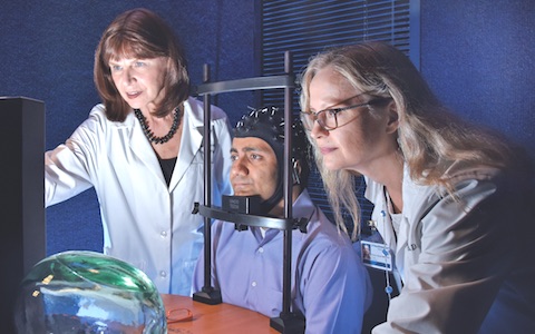 Dr. Carol Tamminga (left) and Dr. Elena Ivleva demonstrate one of the diagnostic tests used in their study that identified new brain-based biomarkers of psychosis.