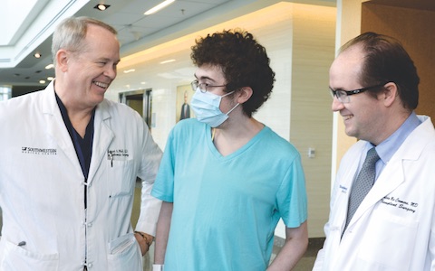 Josiah Ferrell, center, meets with his transplant surgeons, Dr. Michael Wait, left, who performed his lung transplant, and Dr. Malcolm MacConmara, right, who performed the liver transplant