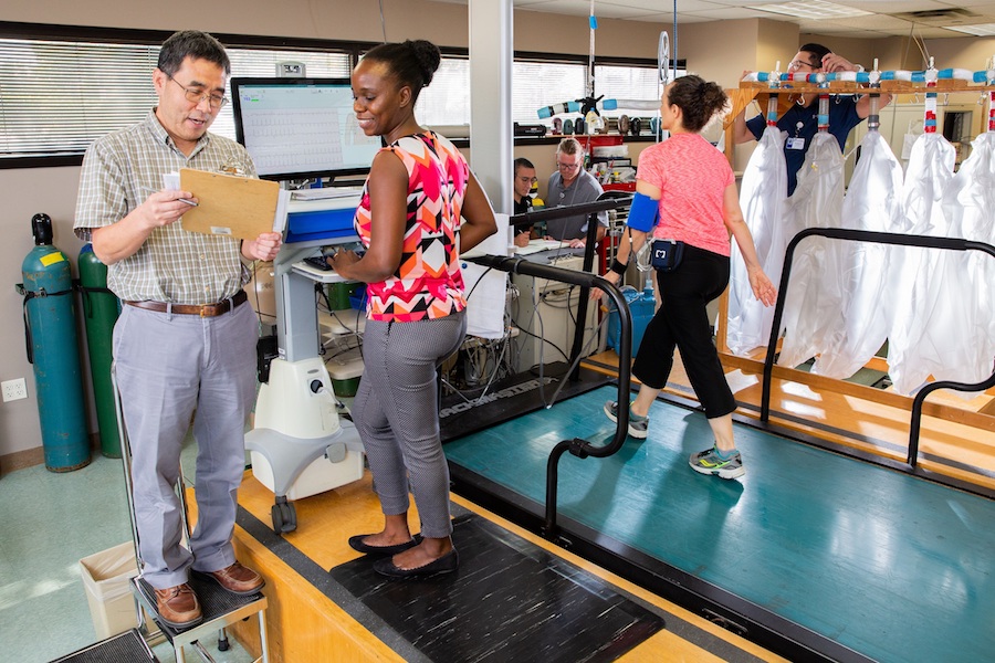 Dr. Rong Zhang reviews data with a woman who is on a treadmill