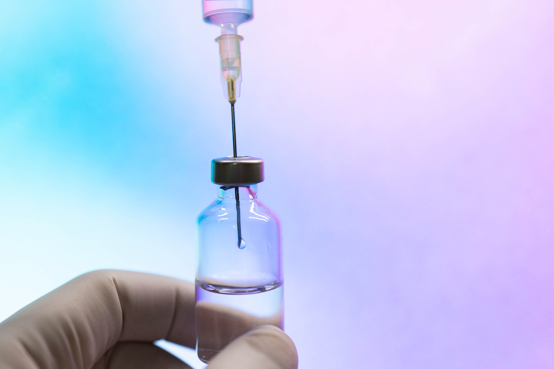 Syringe inserted into a vaccine vial
