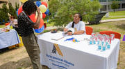 Gabrielle Hawthorne greets attendees with free items and games at the African American Alliance table.
