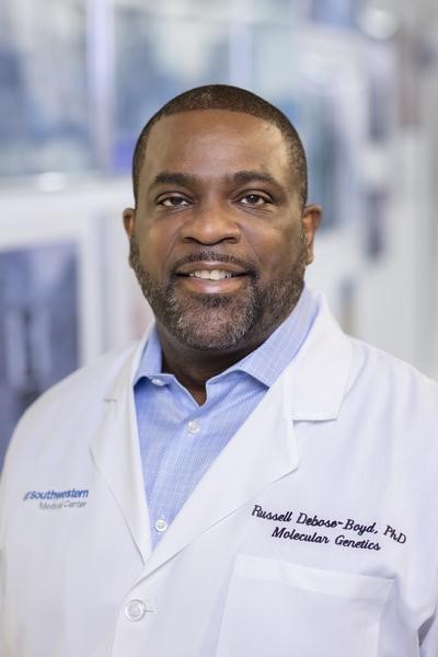 headshot of  Russell DeBose-Boyd black doctor in white coat against glass atrium background