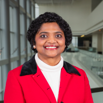 A woman with black hair, wearing a red blazer