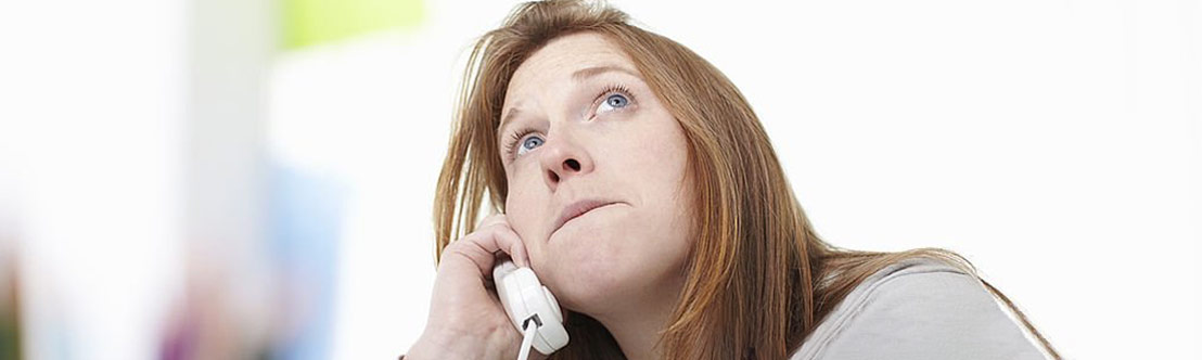 woman with sad expression holds phone to her ear