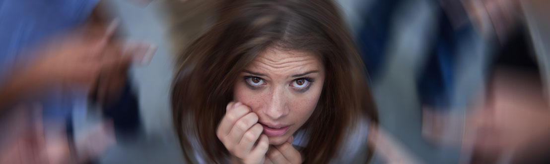 stressed looking young woman looking up with blurred swirl around her head