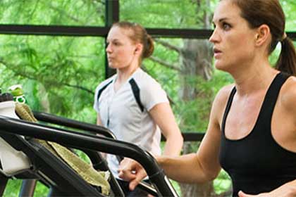 Two women running on treadmills