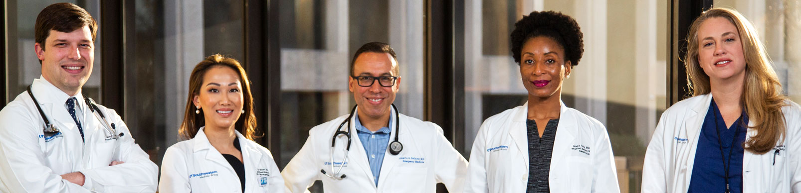 4 medical professionals stand side by side in white coats