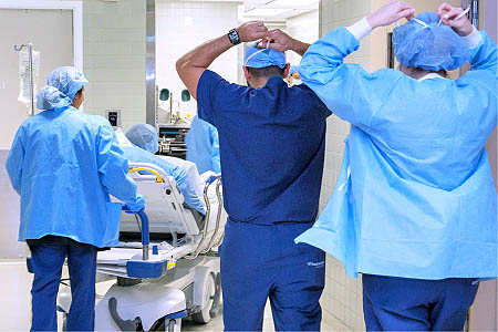 Three medical professionals and a patient in the hallway of a hospital