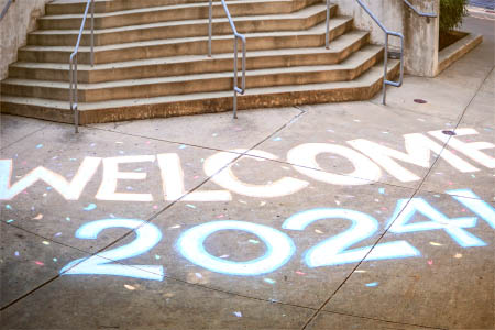 Students posing next to welcome sign