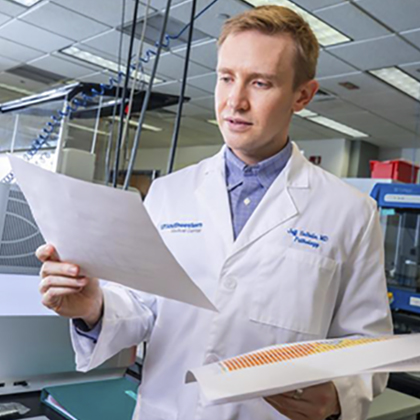 A male doctor examines data on paper reports