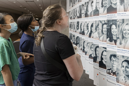 Students looking at the Celebrating Breakthroughs wall at UTSW