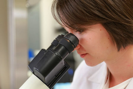 A female medical professional looking into a stethoscope