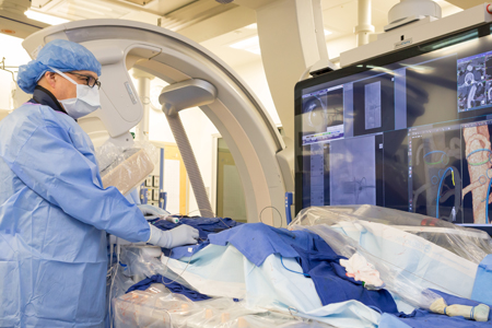 A medical doctor in operating room, wearing a mask and protective clothing