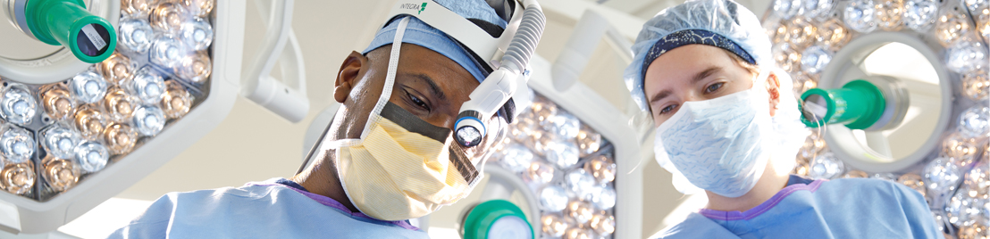 Two medical doctors, wearing masks, looking down in operating room