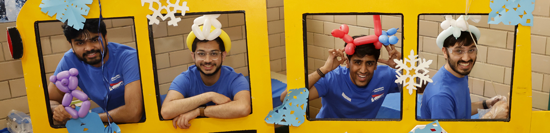 Four men at an event with ballons