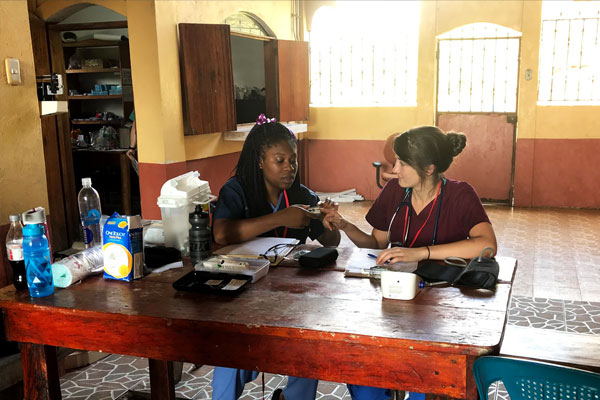 Two women working at a table in an office in rural Guatemala