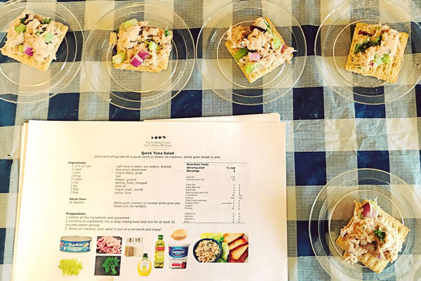Small plates of tuna salad prepared with the recipe card in front