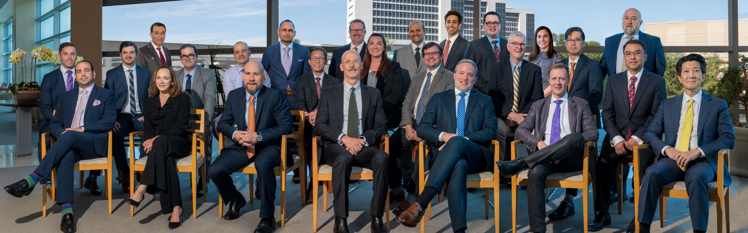 The entire Plastic Surgery Department, dressed up and posed in front of a large window.