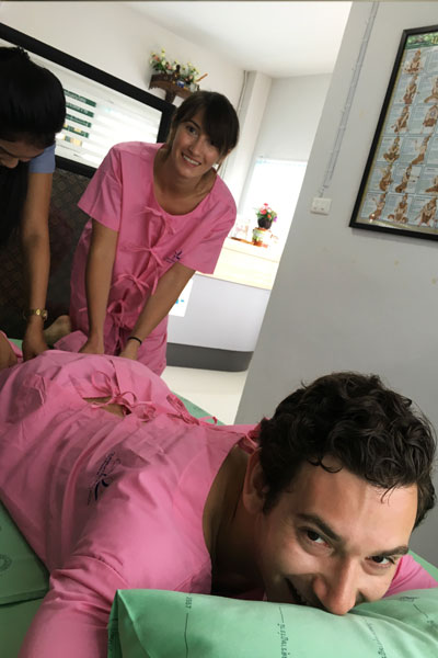 Taylore King learns proper technique for a traditional Thai healing massage (Surat Thani) on a man's leg