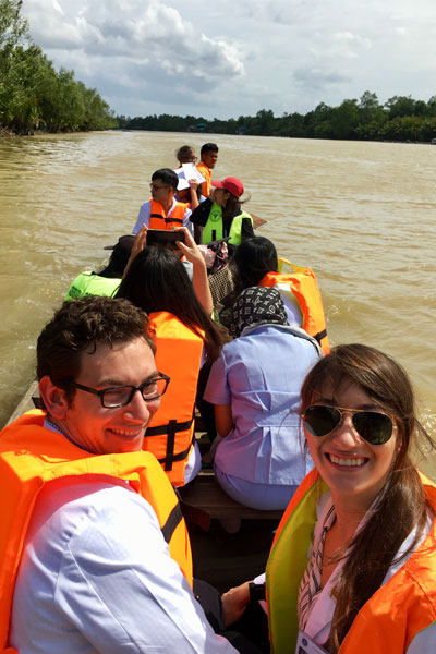 Taylore King, physicians, and nurses ride in a canoe on a river in Thailand