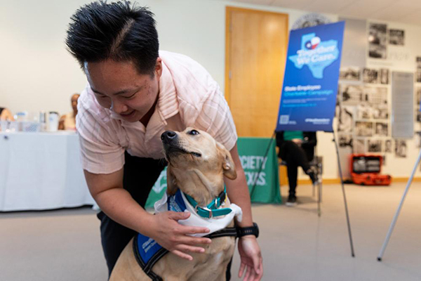 Man giving hug to yellow lab, Tia