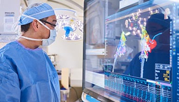 Medical professional wearing mask, looking at screen