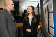 Dr. Michael Cripps reviews the research of medical student Shan Su at the 57th Annual Medical Student Research Forum.