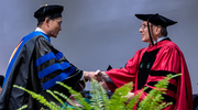 Immunology graduate Cong Xing, Ph.D., is congratulated by Dr. Podolsky.