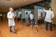 UT Southwestern faculty judges meet with student poster presenters to assess projects.
