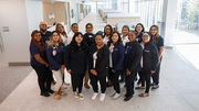 The support staff who help patients at the front desk and with registration and scheduling pose for a group photo.