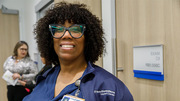 LacKeisha Brown, Certified Medical Office Assistant (CMOA), and (in the background) Elsa Herrera, a Clinical Staff Supervisor, are two of RedBird's employees.