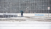 A lone walker ventures down a snowy sidewalk to Clements University Hospital.