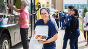 Marilisa Soto Gonzalez picks up her order of El Morro Churrasco from Mi Perú Borinqueño food truck.