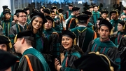 Surrounded by a sea of students, Meghana Reddy, M.D., and Ofelia Negrete Vasquez, M.D., are cheerful waiting for the ceremony to begin.