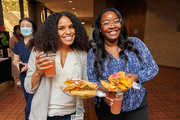 Two employees show off tasty ethnic foods at the reception.