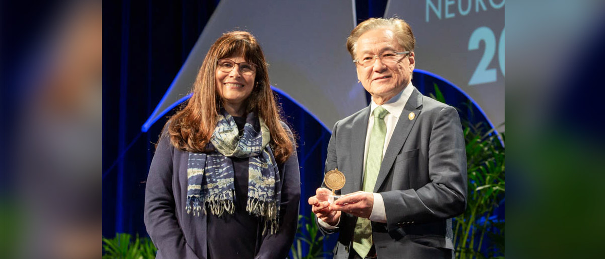 Woman giving award to man on stage