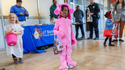 Young trick-or-treaters pose for a photo by the UT Southwestern Police Department table.