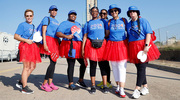 A group rocks their red tutus with Reunion Tower in the background.