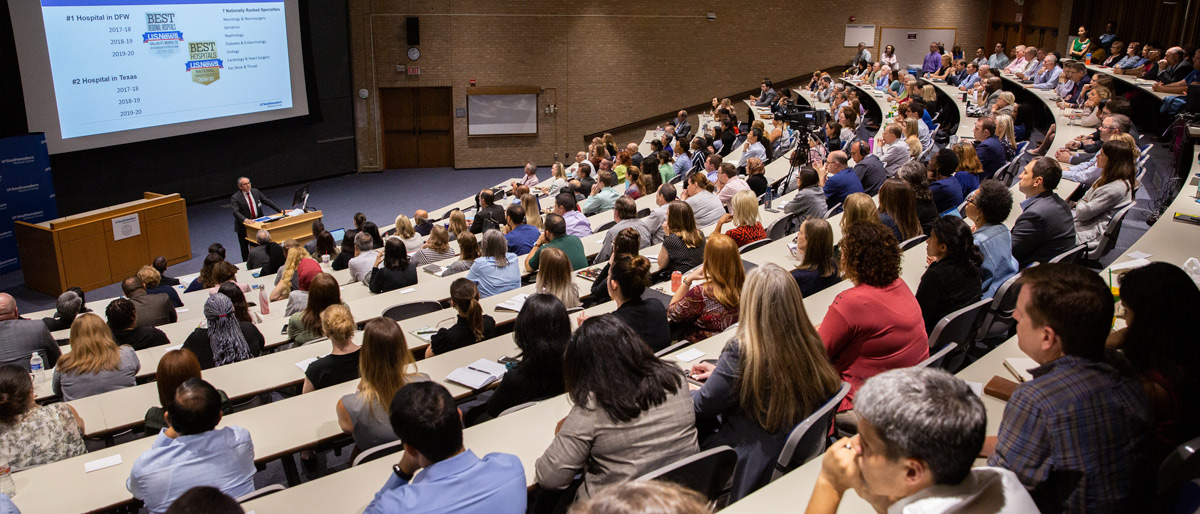 Lecture hall filled with people listening to a speaker