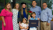Ashlyn Parides (in gown) celebrates achieving her 2021 degree with family.