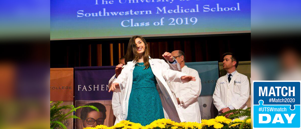 Woman donning on white lab coat on a stage